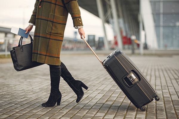 woman leaving an airport with her suitcase